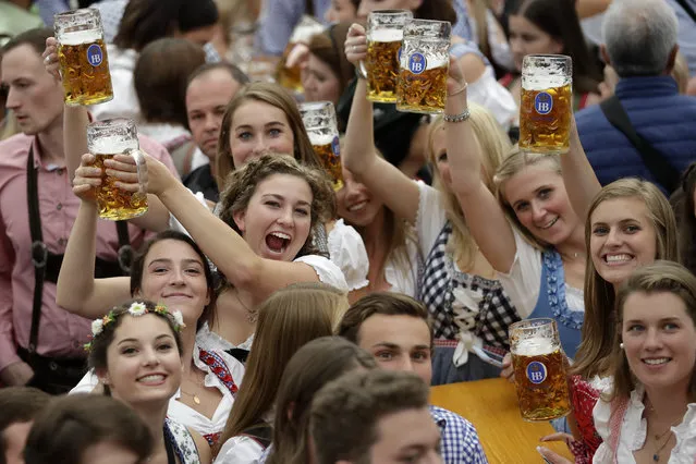 In this October 7, 2018 file photo young women lift glasses of beer during the opening of the 185th “Oktoberfest” beer festival in Munich, Germany. (Photo by Matthias Schrader/AP Photo)