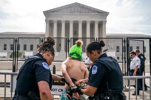 Capitol police arrest a topless abortion-rights activist in front of the Supreme Court on June 14, 2022 in Washington, DC. The court is set to announce a number of high-profile decisions before the end of June. (Photo by Nathan Howard/Getty Images)