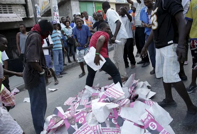 A protester (C) rubs his backside with an electoral poster of presidential candidate Jovenel Moise during a demonstration rallying for the resignation of President Michel Martelly in Port-au-Prince, Haiti, January 23, 2016. Haiti braced for more demonstrations against outgoing President Michel Martelly on Saturday even after authorities buckled to pressure and canceled a presidential election the opposition said was riddled with fraud. (Photo by Andres Martinez Casares/Reuters)