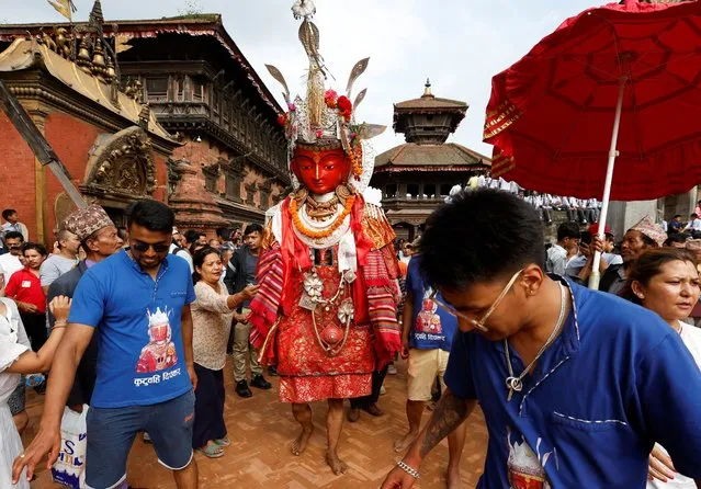 A devotee, cloaked inside the statue of Buddha, parades during the Pancha Dan (giving away of five elements) festival at Bhaktapur Durbar Square in Bhaktapur, Nepal on September 12, 2023. (Photo by Navesh Chitrakar/Reuters)