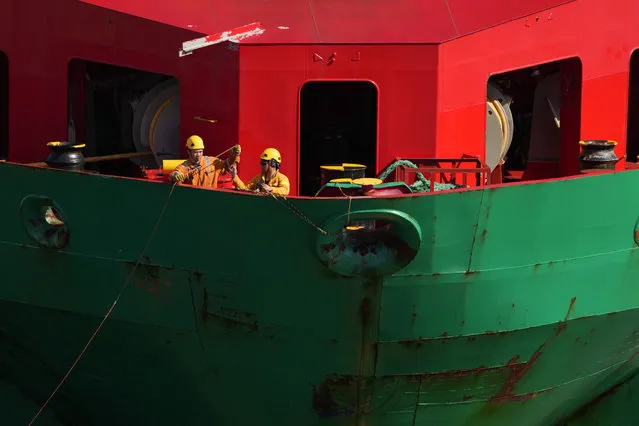 Crew members aboard the Bakkafoss cargo ship prepare the bow line as the vessel arrives in Portland, Maine, with a shipment of containers, Tuesday, October 3, 2023. (Photo by Robert F. Bukaty/AP Photo)