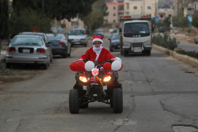 A boy dressed as Santa Claus rides a Christmas decorated vehicle in Jiyeh, south Lebanon December 23, 2016. (Photo by Aziz Taher/Reuters)