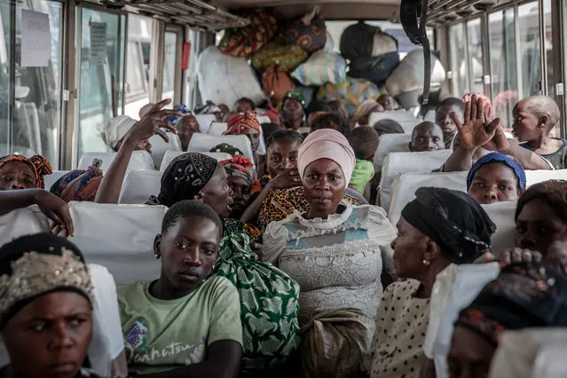 Displaced people who fled Goma after the eruption of the Nyiragongo volcano wait on a bus in Sake with their belongings, waiting to be taken home on June 8, 2021. (Photo by Guerchom Ndebo/AFP Photo)