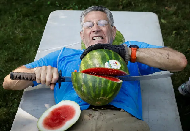 Ashrita Furman, who holds more Guinness World Records than anyone, attempts to set a new record for slicing the most watermelons in half on his own stomach in one minute in New York City, July 17, 2018. (Photo by Brendan McDermid/Reuters)