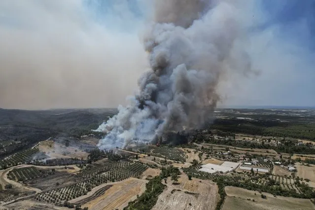 An aerial photo shows wildfires in Kacarlar village near the Mediterranean coastal town of Manavgat, Antalya, Turkey, Saturday, July 31, 2021. The death toll from wildfires raging in Turkey's Mediterranean towns rose to six Saturday after two forest workers were killed, the country's health minister said. Fires across Turkey since Wednesday burned down forests, encroaching on villages and tourist destinations and forcing people to evacuate. (Photo by AP Photo/Stringer)