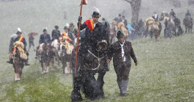 Local residents dressed in traditional Bavarian clothes of the region  ride through heavy snowfall  at the traditional Georgi (St, George)  horse riding procession on Easter Monday in Traunstein, southern Germany, Monday, April 6, 2015. (Photo by Matthias Schrader/AP Photo)