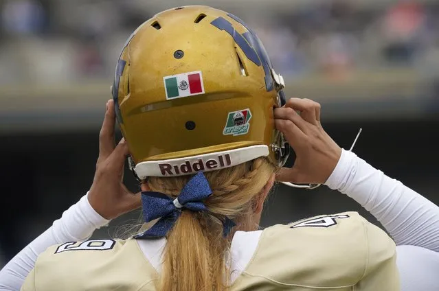 Pumas' kicker Andrea Martinez adjusts her helmet during a Liga Mayor football match against Aztecas in Mexico City, Saturday, October 8, 2022. Martinez stopped playing soccer to become the first woman to play college football amongst men in Mexico's top amateur division. (Photo by Fernando Llano/AP Photo)