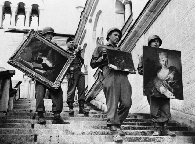 American soldiers remove some of the paintings that were found among the loot the Germans had gathered in Neuschwanstein Castle, at Fussen, Austria, near the Swiss frontier, May 22, 1945. The castle was captured by units of the U.S. 7th Army. The paintings were the Weissman collection, and a portrait of a lady marked “Rothchild collection 16th described (left to right) as being: a picture of a “Cat and Mirror”, Brouver, belonging to century”, but otherwise unidentified. (Photo by AP Photo)