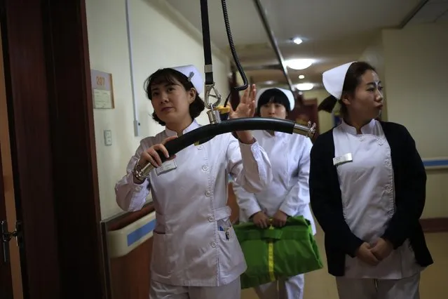 Nurses demonstrate how to use a device that helps the mobility of elderly patients, at the Yanda Hospital, Sanhe City, Langfang, Hebei Province of China, 23 February 2016. The privately owned Yanda hospital, situated 34 kilometres east of Beijing city, is part of a co-ordinated development plan for the Beijing-Tianjin-Hebei area. Medical experts, doctors, and nurses, from major hospitals of Beijing city will colaborate to improve medical services and health care in Hospitals outside of the city. (Photo by How Hwee Young/EPA)