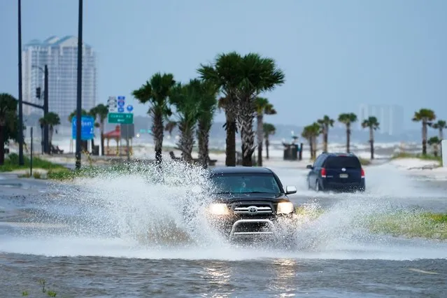 Cars drive through flood waters along route 90 as outer bands of Hurricane Ida arrive Sunday, August 29, 2021, in Gulfport, Miss. (Photo by Steve Helber/AP Photo)