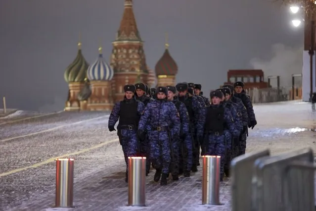 Police and the Rosguardia (National Guard) servicemen walk on the Red Square with the St. Basil's Cathedral in the background in Moscow, Russia, Sunday, December 31, 2023. The Red Square is closed for celebrations on the New Year's Eve. (Photo by Marina Lystseva/AP Photo)