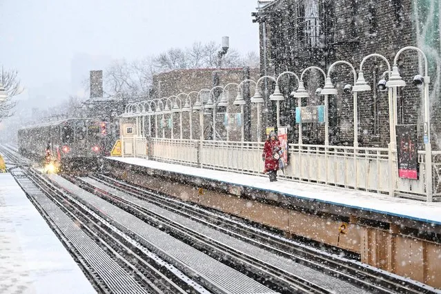 A commuter walks on the platform at the CTA Damen Blue Line station as it snows on Tuesday, January 9, 2024 in Chicago, Illinois. Chicago dodged a snow storm that was forecasted to see 3 to 6 inches of snow but instead received a snowy rain mixture making road conditions slick. (Photo by Joshua Lott/The Washington Post)