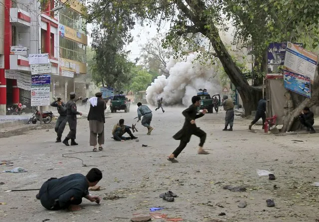 People run for cover after an explosion in Jalalabad April 18, 2015. A suicide bomb blast in Afghanistan's eastern city of Jalalabad killed 33 people and injured more than 100 outside a bank where government workers collect salaries, the city's police chief said on Saturday. (Photo by Reuters/Parwiz)
