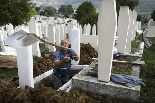 A man throws a shovel after digging graves for COVID-19 victims at the Bare cemetery in Sarajevo, Bosnia, Friday, September 24, 2021. The COVID-19 rate of infections in Bosnia, a country where only about 12% of the population is fully vaccinated against COVID-19, is on a rising trend over the past weeks. (Photo by AP Photo/Stringer)