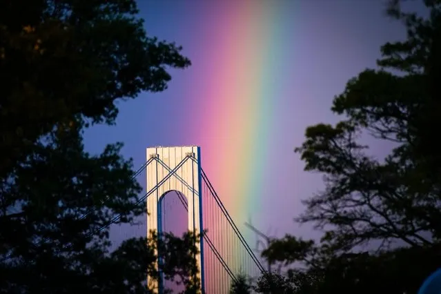 A rainbow appears over the Verrazzano-Narrows Bridge in New York, Monday, September 18, 2023. (Photo by Bryan Woolston/AP Photo)