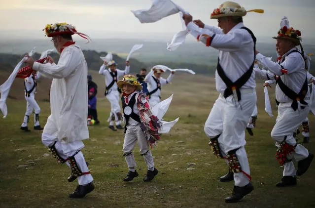 A boy dances with Leicester Morrismen dance during May Day celebrations at Bradgate Park in Newtown Linford, Britain May 1, 2015. (Photo by Darren Staples/Reuters)