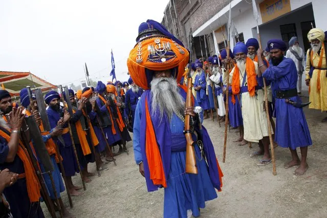 Major Singh (C), a “Nihang” or Sikh warrior, wearing a traditional 425-metre-long turban holds his weapon before taking part in a procession during the Holla Mohalla festival in Anandpur Sahib in the northern state of Punjab, India, March 24, 2016. (Photo by Ajay Verma/Reuters)