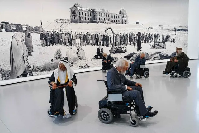 This photograph taken at the Bourse de Commerce – Collection Pinault in Paris on March 13, 2024, shows part of the work of Chinese artists Sun Yuan and Peng Yuin composed of 13 automatic wheelchairs carry sculpted, hyper-realistic, life-size old men, forming a macabre choreography, on display during a press preview. Entitled “Le monde comme il va” (“The world as it is”), the exhibition runs until September 2024, and features “around sixty works from this private collection, which comprises more than 10,000 works, brought together in their relationship to the present and current events, with artists who react and whose works provoke reactions”, curator Jean-Marie Gallais told AFP. (Photo by Dimitar Dilkoff/AFP Photo)