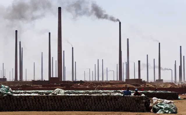 Chimneys are seen as labourers work at a traditional brick factory in Arab Mesad district of Helwan, northeast of Cairo, May 14, 2015. (Photo by Amr Abdallah Dalsh/Reuters)