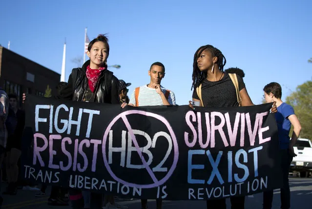 In this March 29, 2016 photo, Mitch Xia, left, rallies with other organizers during a march on Franklin Street against N.C. House Bill 2 in Chapel Hill, N.C. The new state law requires transgender people to use the restroom of their biological gender, not the gender with which they identify. Stung by setbacks related to their access to public restrooms, transgender Americans are taking steps to play a more prominent and vocal role in a nationwide campaign to curtail discrimination against them. (Photo by Whitney Keller/The Herald-Sun via AP Photo)