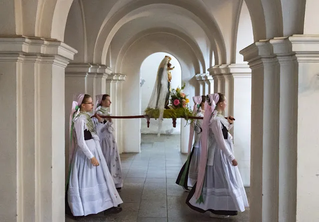 Women dressed in the traditional clothes of the Sorbs carry the statue of Virgin Mary during a procession in the Roman Catholic pilgrimage church in Rosenthal, eastern Germany, Monday, June 10, 2019. Traditionally on White Monday catholic faithful Sorbs, a Slavic minority near the German-Polish border, celebrate an open air mass in the small village east of Dresden. (Photo by Jens Meyer/AP Photo)