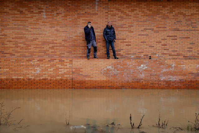 Local residents look on at flood water in the town of Fushe Kosove, Kosovo, 11 January 2021. Due to heavy rain showers many areas were flooded across Kosovo. (Photo by Valdrin Xhemaj/EPA/EFE)