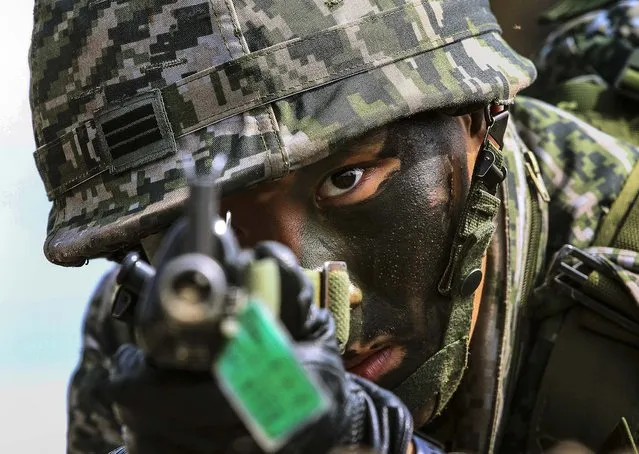 A South Korean marine aims his machine gun during the U.S.-South Korea joint landing exercises called Ssangyong, part of the Foal Eagle military exercises, in Pohang, South Korea, on March 31, 2014. (Photo by Ahn Young-joon/Associated Press)