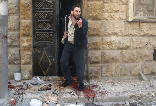 A man reacts as he stands on blood stains at a site hit by airstrikes in the rebel held area of Aleppo's al-Fardous district, Syria, April 29, 2016. (Photo by Abdalrhman Ismail/Reuters)