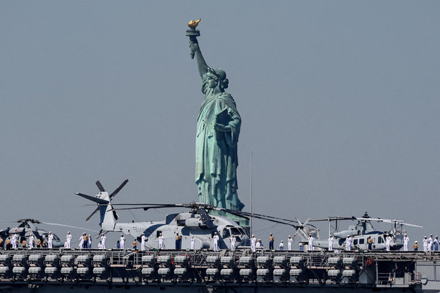 Sailors and Marines line the deck of the USS Bataan (LHD-5) Wasp-class amphibious assault ship, as it passes by the Statue of Liberty arriving in New York Harbor during the parade of ships to kick off “Fleet Week 2024” in New York City, U.S., May 22, 2024. (Photo by Brendan McDermid/Reuters)