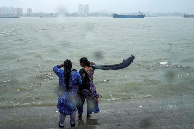 Onlookers watch a raging Hooghly River with high wind in Kolkata, India, as rain continues after cyclone Remal made a landfall near Bangladesh-India border, Monday, May 27, 2024. (Photo by Bikas Das/AP Photo)