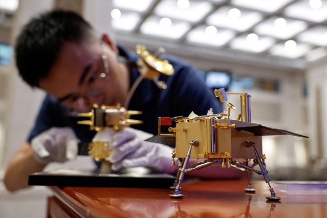 A staff member assembles a model of Chang'e 6 lunar probe ahead of a press conference on Chang'e 6 mission of China's lunar exploration program, in Beijing, China on June 27, 2024. (Photo by Tingshu Wang/Reuters)