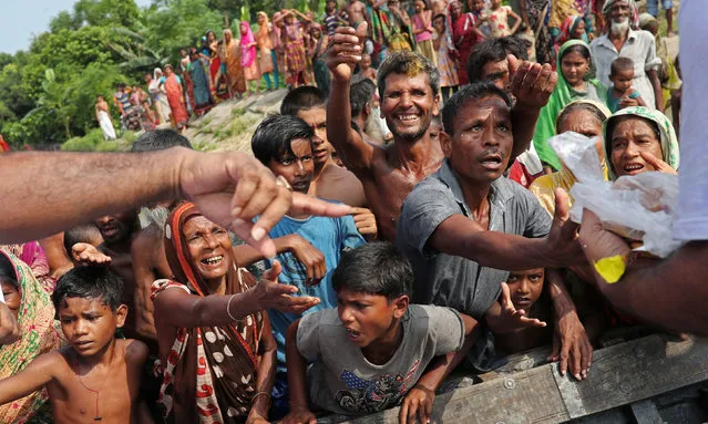 Flood-affected people gather to receive relief supplies distributed by volunteers in Jamalpur, Bangladesh, July 21, 2019. (Photo by Mohammad Ponir Hossain/Reuters)