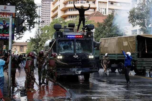 A demonstrator climbs on a police vehicle as police use water cannons to disperse protesters during a demonstration against Kenya's proposed finance bill 2024/2025 in Nairobi, Kenya, on June 25, 2024. (Photo by Monicah Mwangi/Reuters)