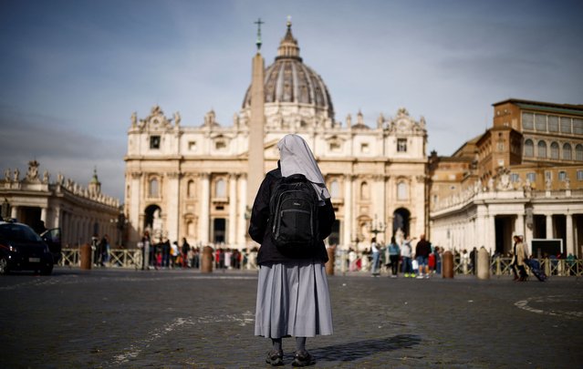 A nun stands in front of St. Peter’s square after Pope Francis was hospitalised for a respiratory infection, at the Vatican on March 30, 2023. (Photo by Yara Nardi/Reuters)