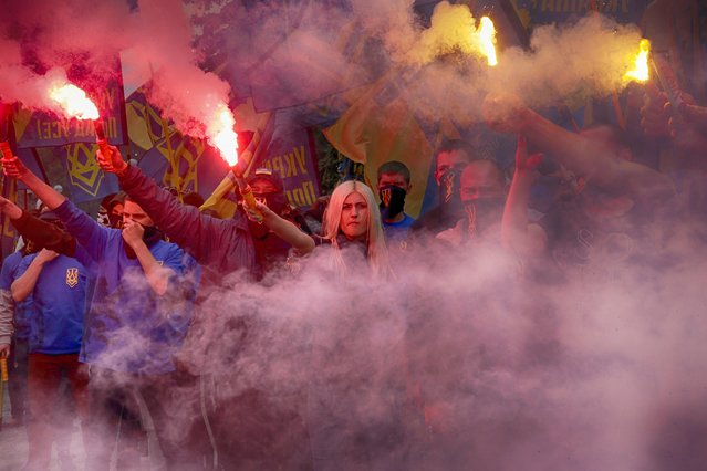 Volunteers of the “Azov” Civil Corps light flares during rally at the Ukrainian Parliament, Friday, May 20, 2016, against holding local elections in the occupied eastern territories of Ukraine. As part of an internationally brokered peace agreement, Ukraine must hold local elections in two eastern regions controlled by Russian-backed rebels, but there are major concerns about ensuring the vote takes place in a secure and safe atmosphere. (Photo by Efrem Lukatsky/AP Photo)