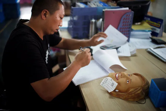 A mask of U.S. Democratic presidential candidate Hillary Clinton is placed on the desk of a staff member at Jinhua Partytime Latex Art and Crafts Factory in Jinhua, Zhejiang Province, China, May 25, 2016. (Photo by Aly Song/Reuters)