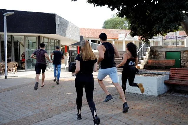 People run to take shelter as a siren warning of incoming rockets sound as a spike in cross-border violence with Gaza continues, in Ashkelon, southern Israel on November 13, 2019. (Photo by Amir Cohen/Reuters)