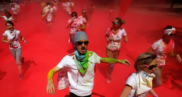 Participants race through clouds of red powder during the Colour Run at the Luzhniki Olympic complex in Moscow on June 11, 2017. (Photo by Maxim Zmeyev/AFP Photo)