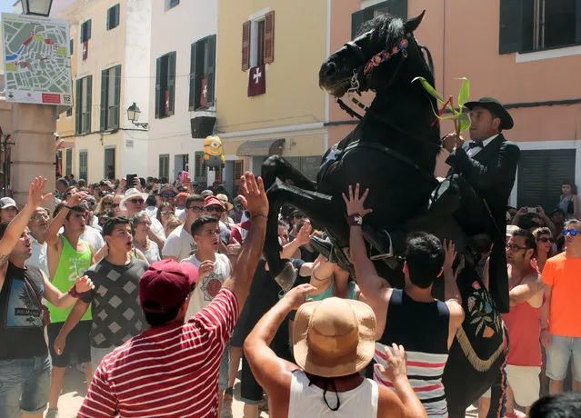 A rider rears up on his horse while surrounded by a cheering crowd during the traditional Fiesta of Sant Joan (Saint John) in downtown Ciutadella, on the island of Menorca, Spain June 24, 2016. (Photo by Enrique Calvo/Reuters)