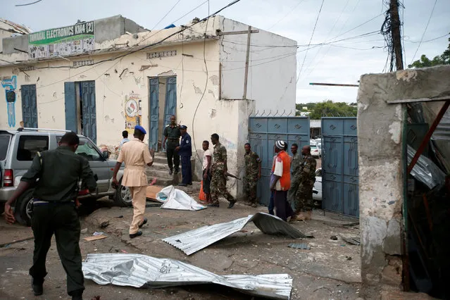 Somali government soldiers and police gather near the scene of gunfire after a suicide bomb attack outside Nasahablood hotel in Somalia's capital Mogadishu, June 25, 2016. (Photo by Feisal Omar/Reuters)