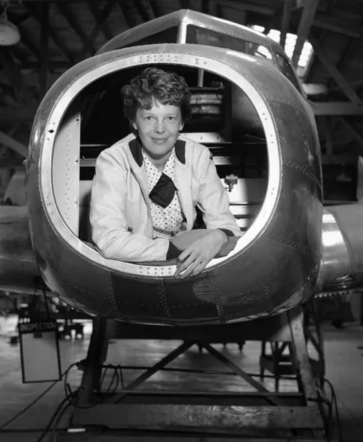 Amelia Earhart, noted flier, inspected the Twin-Engined Lockheed Electra Monoplane which is being built for her use in future long distance flights at the plant, May 26, 1936, Burbank, Calif. The ship will carry 1200 gallons of gasoline and have a cruising range of more than 4500 miles. Photo shows Miss Earhart in plane looking over blueprints. (Photo by AP Photo)