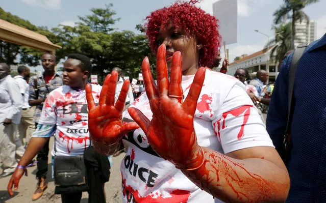 A member of the civil society smears her hands with mock blood as others chant slogans, during a protest dubbed “Stop extrajudicial killings” on the killing of human rights lawyer, Willie Kimani, his client and their driver in Nairobi, Kenya, July 4, 2016. (Photo by Thomas Mukoya/Reuters)
