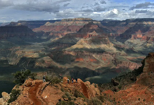 In this February 22, 2005, file photo, with the North Rim in the background, tourists hike along the South Rim of the Grand Canyon in Grand Canyon, Ariz. National Park officials plan to replace much of the decades-old and problem-plagued pipeline that plunges down into the canyon and backs up the other side to supply water to South Rim hotels, campgrounds, and other facilities at the northern Arizona park. (Photo by Rick Hossman/AP Photo)