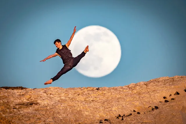 Photographer Fergus Kennedy, 53, took the pictures of his son Alfie Kennedy, 16, at Seaford Head in East Sussex on April 15. The picture show the dance student dancing in front of the full moon as it appeared above the horizon behind him. (Photo by Fergus Kennedy/Caters News Agency)