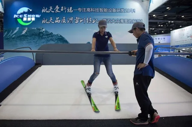 A woman gets a ski lesson on a mechanical ski slope at the China National Convention Centre during the World Winter Sports Expo in Beijing on September 7, 2017. (Photo by Nicolas Asfouri/AFP Photo)
