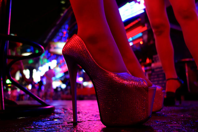 Women stand outside a bar in a red light district in Bangkok, Thailand, July 12, 2016. Thailand’s infamous sеx industry is under fire, with the tourism minister pushing to rid the country of its ubiquitous brothels and a spate of police raids in recent weeks on some of the largest establishments providing sеx services in Bangkok. Those who work in the industry say curbs on commercial sеx services will hurt a flagging economy that has struggled to recover after political turmoil took the country to the brink of recession in 2014. Thailand is predominantly Buddhist and deeply conservative, but is home to an extensive sеx industry, largely catering to Thai men. Hordes of tourists also flock to the bright lights of go-go bars and massage parlors in Bangkok and main tourist towns. (Photo by Jorge Silva/Reuters)