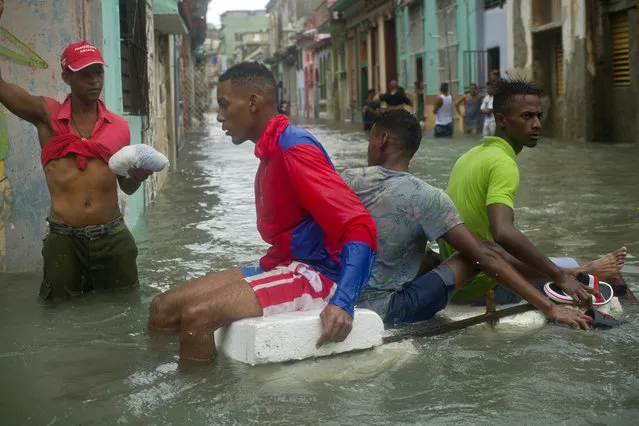 Residents float down a flooded street in Havana atop a large piece of styrofoam, after the passing of Hurricane Irma in Cuba, Sunday, September 10, 2017. (Photo by Ramon Espinosa/AP Photo)