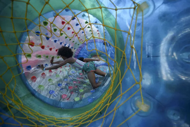 Jayla Kennett, 11, from Bellows Falls, rolls around in an inflatable floating ball at the Waypoint Center during the 45th annual Rockingham Old Home Days on Saturday, August 6, 2022 in Bellows Falls, Vt. (Photo by Kristopher Radder/The Brattleboro Reformer via AP Photo)