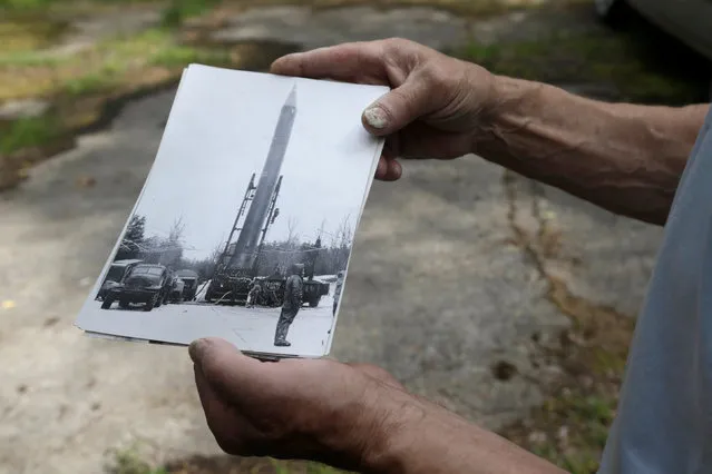 Former Soviet Army officer Vladimir Procenko shows a picture of the Soviet R12 nuclear missile near the abandoned launch site in Zeltini, Latvia, July 22, 2016. (Photo by Ints Kalnins/Reuters)