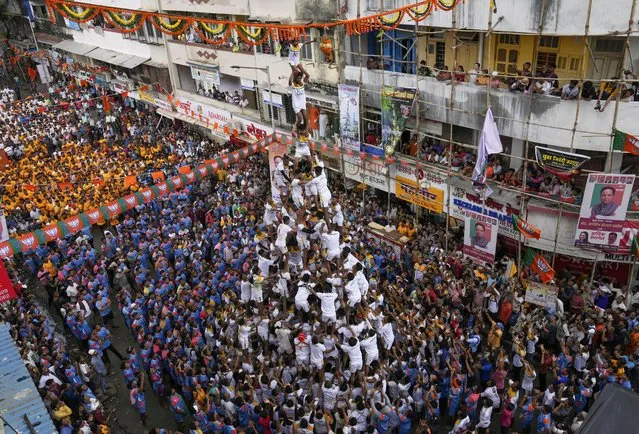 People form a human pyramid to break the “Dahi handi”, an earthen pot filled with curd, as part of celebrations to mark Janmashtami festival in Mumbai, India, Friday, August 19, 2022. (Photo by Rajanish Kakade/AP Photo)